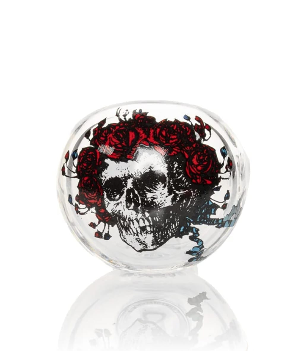 Close-up of glass spoon pipe bowl with Bertha skull and red roses decal design